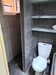 ein Badezimmer mit einer weißen Toilette in einem Zimmer in der Unterkunft Hameau du Puech, rez-de-jardin avec parking et clim in Cap d'Agde