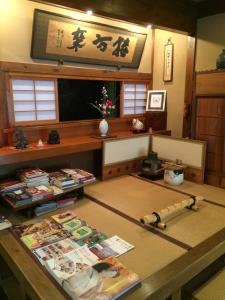 a room with a table with books and a table sidx sidx at Yadoya Kikokuso in Kyoto +31 photos