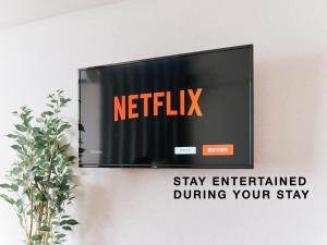 a television on a wall with a netflix sign at Evergreen Apartment Hotel in Tokyo