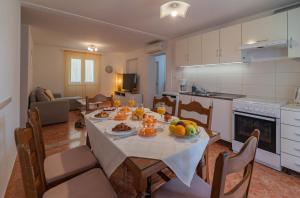 a kitchen and living room with a table with fruit on it at Apartman Domenika in Makarska