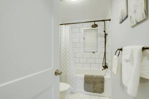 a white bathroom with a tub and a toilet at Le petit refuge in Gatineau