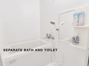a white bathroom with a shower and a sink at Evergreen Apartment Hotel in Tokyo +12 photos