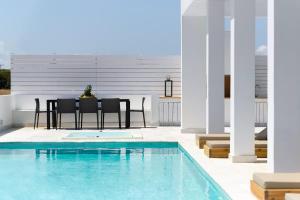 a patio with a table and chairs next to a swimming pool at Seacalm Villa in Lachania +18 photos