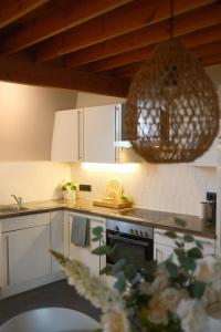 a kitchen with white cabinets and a chandelier at La mezzanine 159 in Namur +17 photos