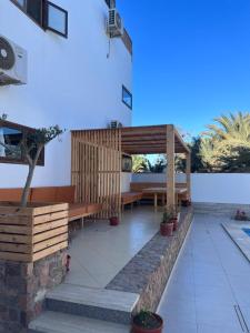 a patio with a wooden pergola and benches at Casablanca1 in Dahab
