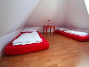 two red beds in a room with a table at Ferienwohnungen am Flacher See, Klocksin in Klocksin