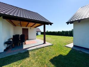 a pavilion with chairs and a table in a yard at Nadmorska Kępa in Kąty Rybackie