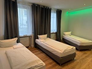 una camera con tre letti in una stanza con finestre di Graf-Adolflux a Dusseldorf