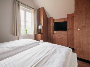 a bedroom with a white bed and a television at Ferienhaus in Schierke for 8 Personen in Schierke