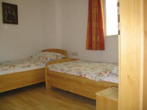 two beds in a small room with a window at Pension Sarstein in Hallstatt +12 photos