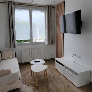 a small living room with a couch and a table at petite maison 3km de la mer in Ozeville