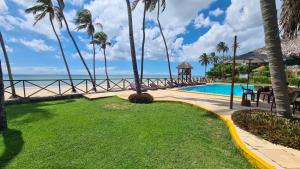 a resort swimming pool with a gazebo and the ocean at Eco Paradise Cumbuco 128 in Cumbuco