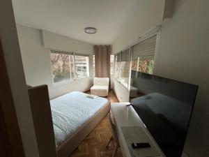 a bedroom with a bed and a flat screen tv at Boutique hotel Oquendo in Madrid