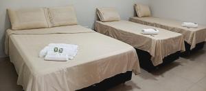 two beds with towels on them in a room at Chalé luar da serra, Camilos, Socorro in Socorro