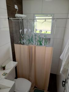 a bathroom with a toilet and a shower curtain at Chalé luar da serra, Camilos, Socorro in Socorro +8 photos