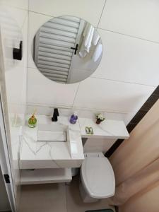 a bathroom with a white toilet and a mirror at Chalé luar da serra, Camilos, Socorro in Socorro