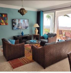 a living room with two couches and a table at Villa du soleil in Mirleft