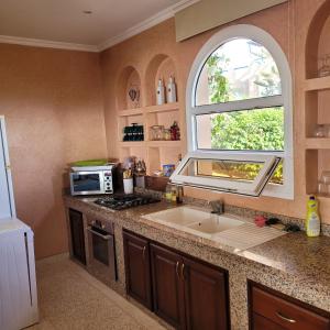 a kitchen with a sink and an arch window at Villa du soleil in Mirleft