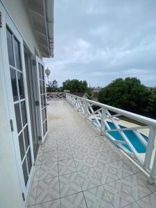 a balcony of a building with a white railing at Mango Tree House in Christ Church