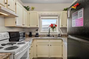 a kitchen with white cabinets and a black refrigerator at 2 King BRs Balcony Resort Amenities Free Tix in Pigeon Forge