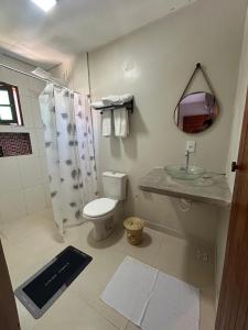 a bathroom with a toilet and a sink and a shower at Casa da Pri Suítes in Pôrto de Pedras +6 photos