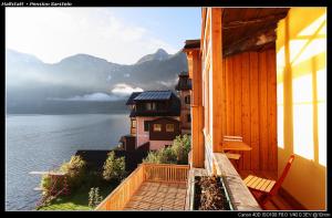 a balcony of a house with a view of the water at Pension Sarstein in Hallstatt
