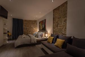 a living room with a bed and a couch at ROKOS SUPERIOR DOWNTOWN ROOMS - comfortable rooms with private bathrooms - perfect location for exploring Diocletian's Palace and the gastronomy of Split within walking distance in Split +41 photos