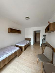 a room with two beds and a chair in it at Penzión Centrum in Terchová