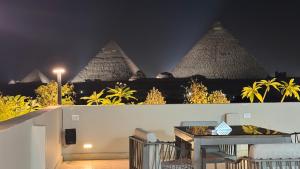 a view of the pyramids from a balcony at night at Zuri Pyramids View Hotel in Cairo