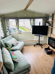 a living room with a couch and a flat screen tv at KEE Holiday Home Caravan in Great Yarmouth
