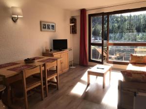 salon ze stołem, kanapą i telewizorem w obiekcie Résidence La Grande Traversee - Charmant studio pied des pistes MAE-4044 w mieście Corrençon-en-Vercors