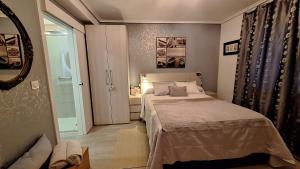 a small bedroom with a bed and a mirror at Chambre et petit déjeuner à Socoa in Urrugne