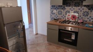 una cocina con estufa y refrigerador en La Voltata, en Pianosinatico