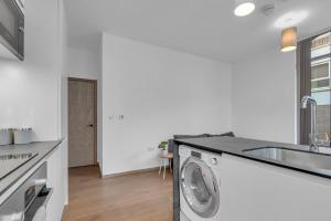 a kitchen with a washing machine and a sink at New Modern Apartment near Heathrow Airport in Yiewsley +13 photos