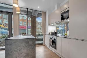 a kitchen with a sink and a stove at New Modern Apartment near Heathrow Airport in Yiewsley