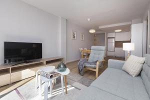 Una sala de estar con un sofá y un televisor. en La Ventana de Formigal by BeValle, en Formigal 21 fotos más