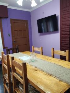 einen Holztisch mit Stühlen und einen TV an einer lila Wand in der Unterkunft Casa a 7 cuadras de la playa in Mar del Plata