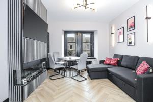 a living room with a couch and a tv and a table at Traditional 1-Bed Edinburgh Apt in Edinburgh