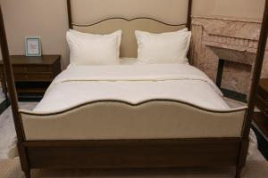 a bed with white sheets and pillows on it at La maison française in Milletville