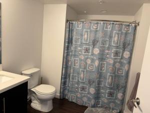 Un baño con inodoro y cortina de ducha. en Incredible Hollywood Loft Free Parking, en Los Ángeles