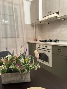 a kitchen with a stove and some flowers on a table at Slatina RECEA RESIDENCE in Slatina