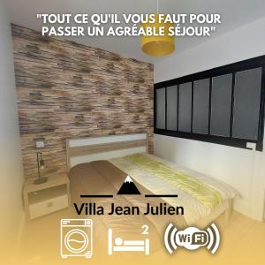 una cama en una habitación con una pared de ladrillo en Villa Jean Julien - Les Cascades - Wifi - 2 chambres - 6 personnes - Terrasse, en Le Mont-Dore