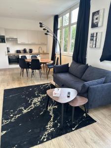 a living room with a couch and a table at Maison de l'Aar Appartement le Diamant luxueux et neuf 2 chambres Grand Salon Séjour in Strasbourg