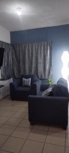 ein Wohnzimmer mit einem Sofa und einer blauen Wand in der Unterkunft Depa totalmente climatizado y tranquilo in Valente Díaz y La Loma