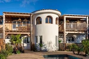 ラカノーにあるLes Villas de Julie au Domaine des Musesのバルコニーとプール付きの広い白い家