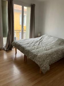 ペルテュイにあるMaison de village à Pertuisのウッドフロアのベッドルーム1室(ベッド1台付)