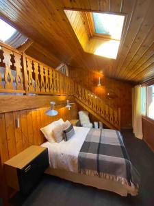 a bedroom with a bed with a wooden wall at Maison Amore Serre Chevalier in Saint-Chaffrey