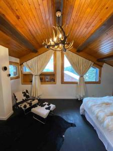 a bedroom with a large bed and a chandelier at Maison Amore Serre Chevalier in Saint-Chaffrey