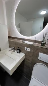 a bathroom with a sink and a mirror at Einzelappartement im Neubau mit Kochnische nähe Legoland in Waldstetten