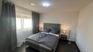 a bedroom with a bed with two lamps and a window at Einzelappartement im Neubau mit Kochnische nähe Legoland in Waldstetten